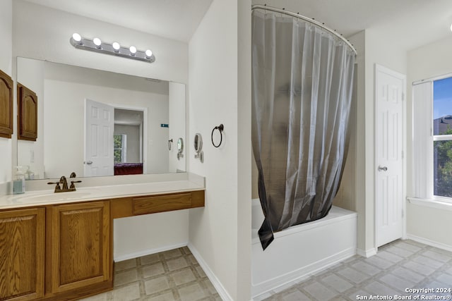 bathroom featuring a wealth of natural light, shower / tub combo, and vanity