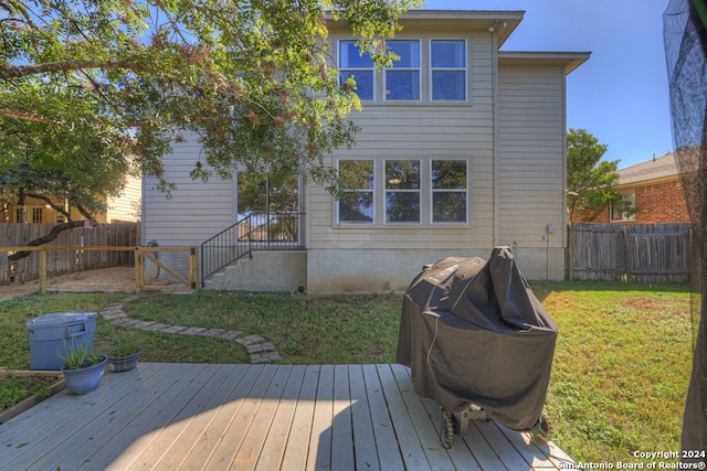 rear view of property featuring a deck and a yard