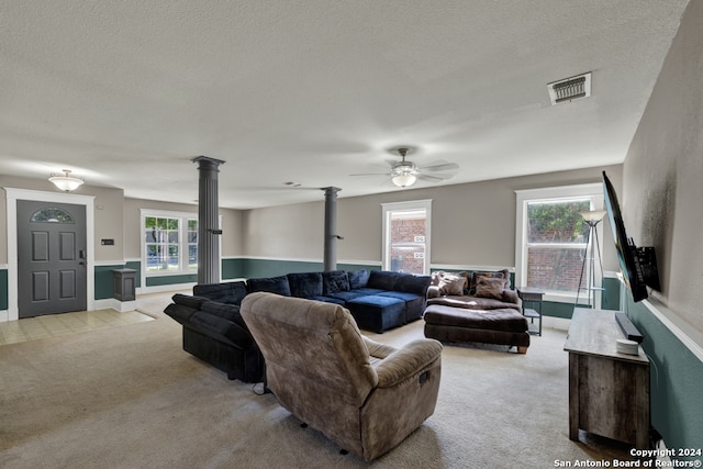 living room featuring light carpet, plenty of natural light, a wood stove, and a textured ceiling