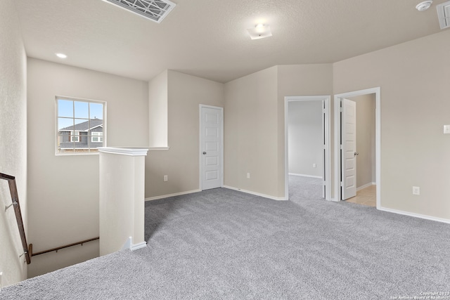 interior space featuring light colored carpet and a textured ceiling