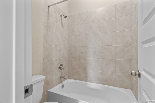 bathroom featuring toilet and tiled shower / bath combo