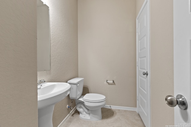 bathroom with toilet and tile patterned floors