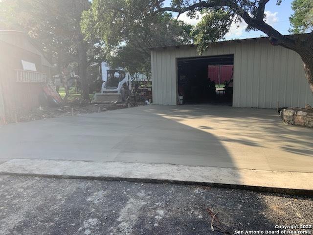 view of outdoor structure with driveway, an outbuilding, and a garage