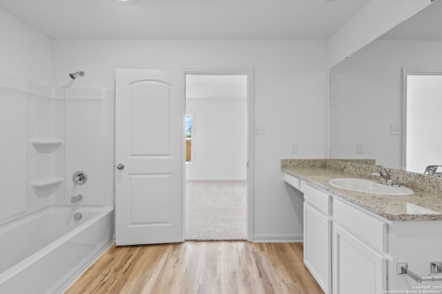 bathroom featuring wood-type flooring, washtub / shower combination, and vanity