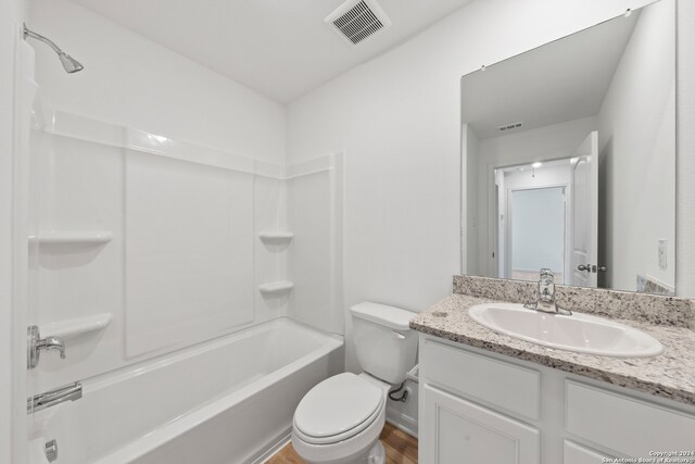 full bathroom featuring wood-type flooring, toilet, bathing tub / shower combination, and vanity