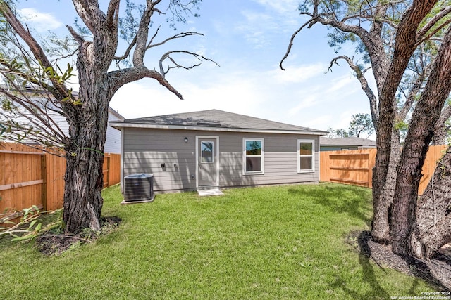 back of property featuring central AC unit and a lawn