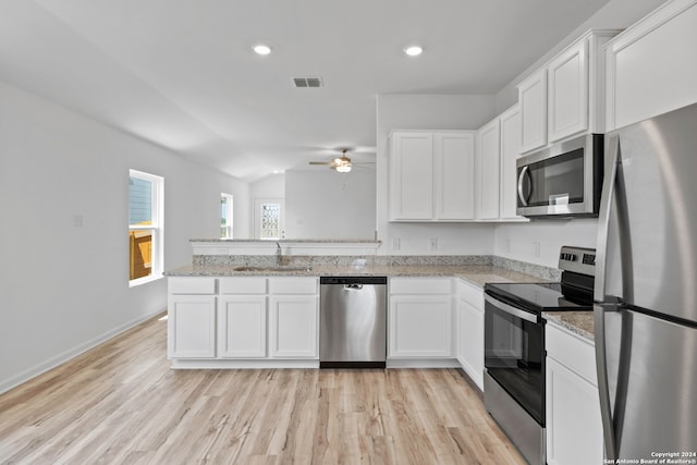 kitchen with ceiling fan, appliances with stainless steel finishes, white cabinetry, and light hardwood / wood-style floors