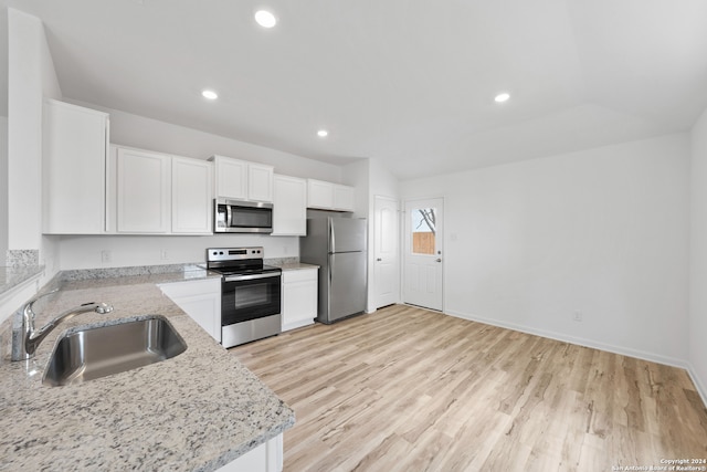 kitchen featuring white cabinetry, light hardwood / wood-style flooring, light stone counters, sink, and appliances with stainless steel finishes