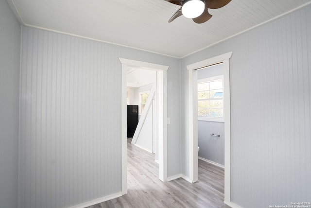 hallway featuring light wood-type flooring and crown molding