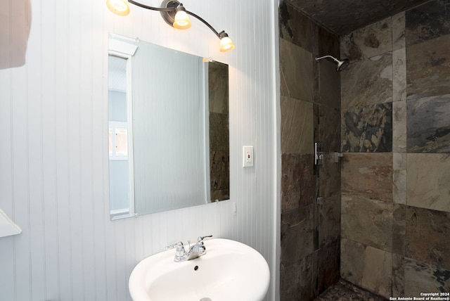 bathroom featuring tiled shower and sink