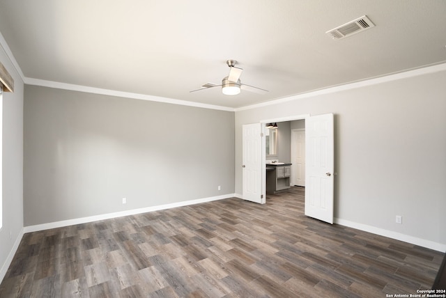 unfurnished bedroom with dark wood-type flooring, ceiling fan, ornamental molding, and ensuite bath