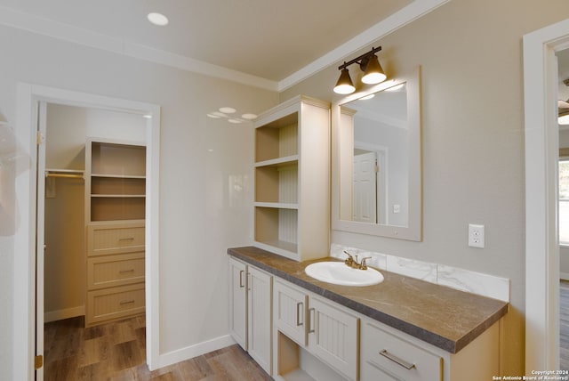 bathroom with vanity, ornamental molding, and wood-type flooring