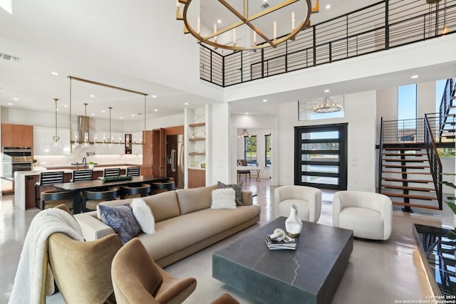 living room with sink, a chandelier, and a towering ceiling