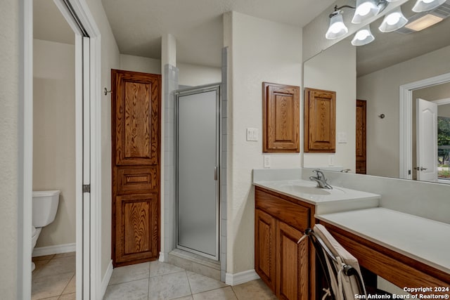 bathroom featuring vanity, toilet, walk in shower, and tile patterned flooring