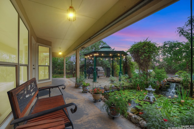 patio terrace at dusk with a grill and a gazebo