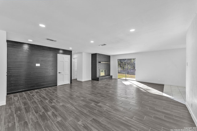 unfurnished living room featuring a fireplace and dark wood-type flooring