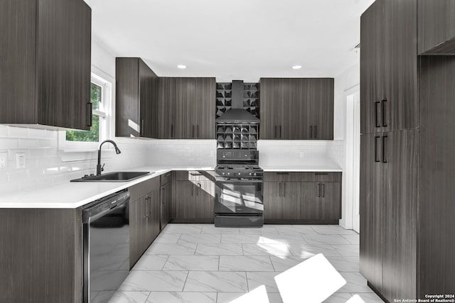 kitchen with dark brown cabinetry, sink, wall chimney range hood, decorative backsplash, and black appliances