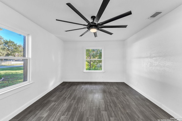 unfurnished room featuring a wealth of natural light, ceiling fan, and dark hardwood / wood-style floors