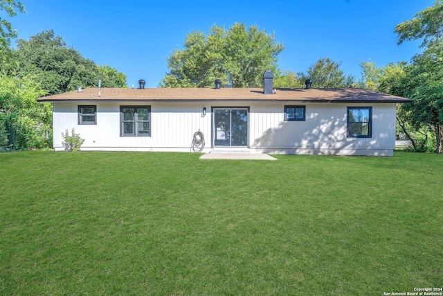 rear view of property with a yard