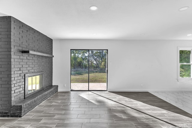 unfurnished living room with a fireplace and a healthy amount of sunlight