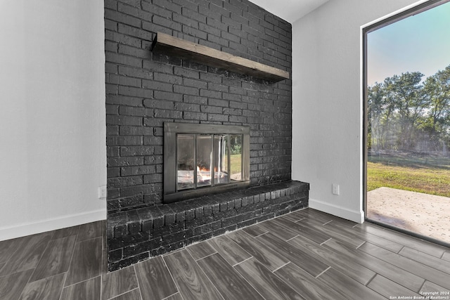 room details featuring wood-type flooring and a brick fireplace