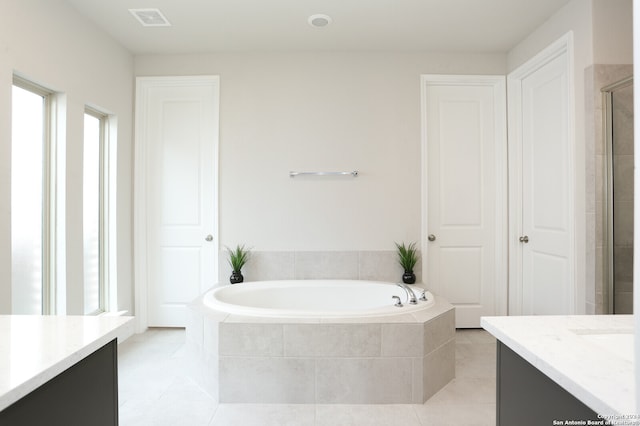 bathroom featuring vanity, plus walk in shower, and tile patterned floors