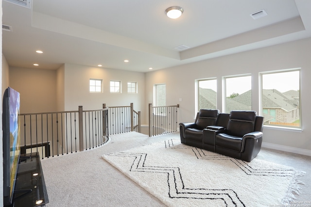 sitting room featuring a tray ceiling, a wealth of natural light, and carpet flooring