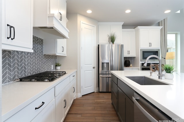 kitchen with backsplash, dark wood-type flooring, stainless steel appliances, sink, and white cabinets