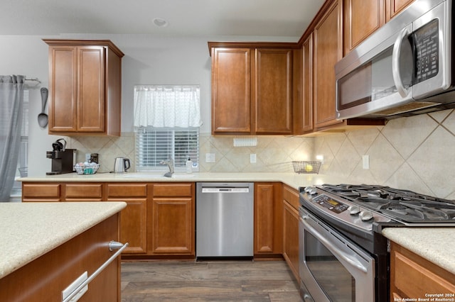 kitchen with decorative backsplash, dark hardwood / wood-style flooring, sink, and stainless steel appliances