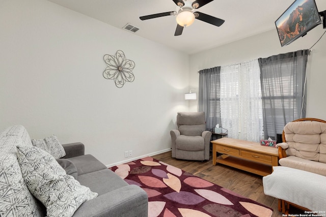 living room with ceiling fan and dark hardwood / wood-style flooring