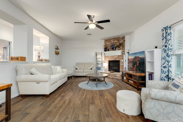 living room featuring a fireplace, dark wood-type flooring, and ceiling fan