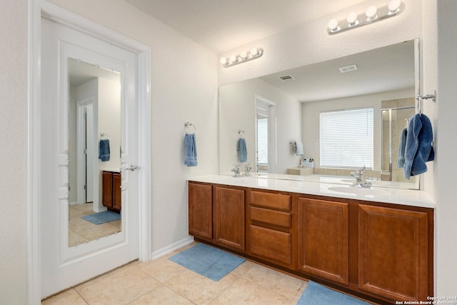 bathroom with vanity, a shower with shower door, and tile patterned flooring