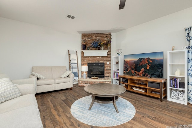 living room featuring ceiling fan, a fireplace, and dark hardwood / wood-style floors