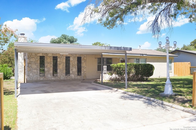 ranch-style home featuring a front yard and a carport