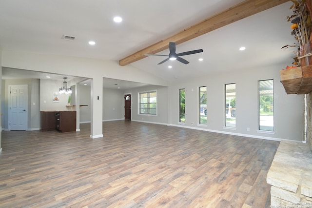 unfurnished living room featuring ceiling fan with notable chandelier, lofted ceiling with beams, and hardwood / wood-style floors