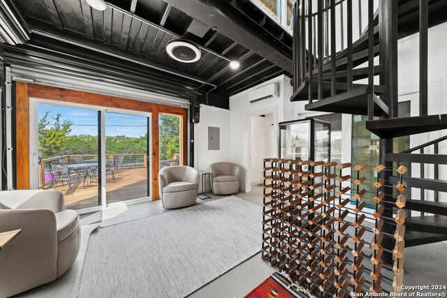 living room with electric panel, concrete floors, and a wall mounted air conditioner