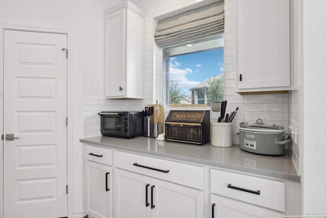 kitchen featuring white cabinetry and decorative backsplash