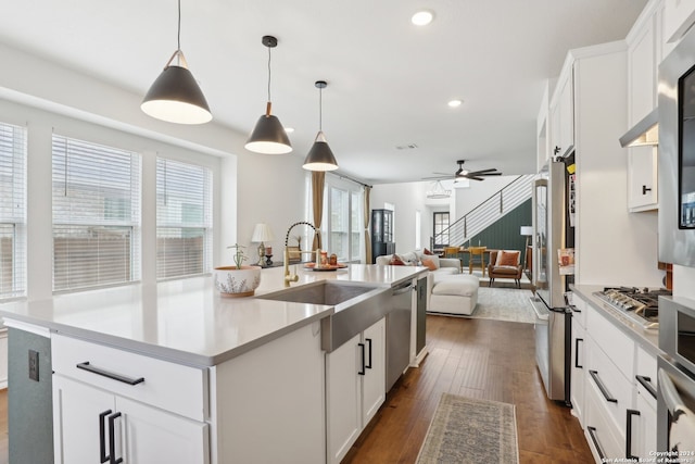 kitchen featuring white cabinets, hanging light fixtures, dark hardwood / wood-style flooring, and sink