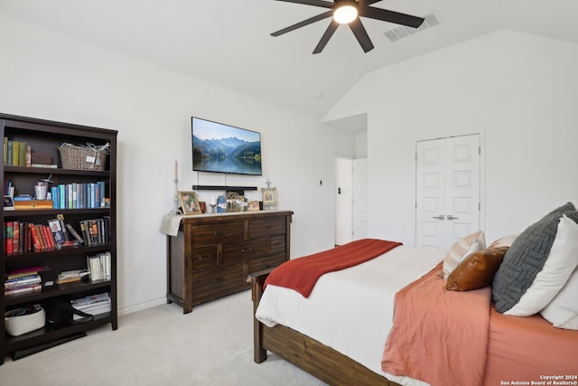 bedroom featuring a closet, vaulted ceiling, light carpet, and ceiling fan