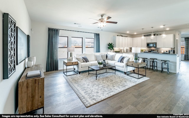 living room featuring ceiling fan and hardwood / wood-style flooring