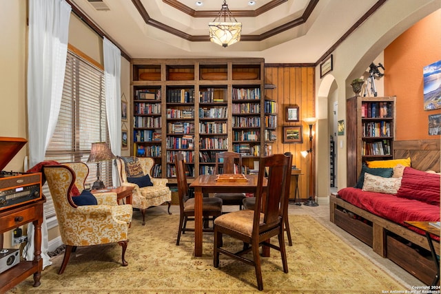 sitting room featuring ornamental molding, wooden walls, and a tray ceiling