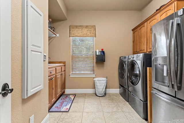 laundry room featuring sink, washing machine and clothes dryer, cabinets, and light tile patterned floors