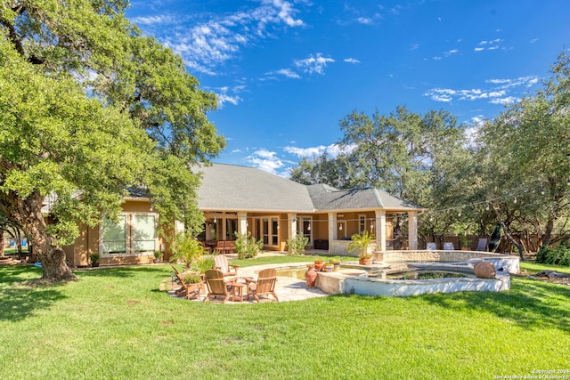 rear view of house featuring a patio area and a lawn