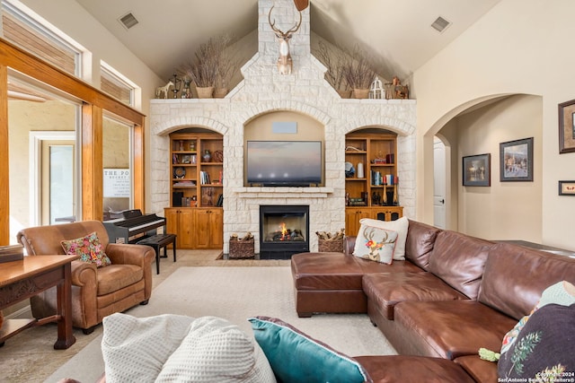 living room with a fireplace, high vaulted ceiling, and built in features