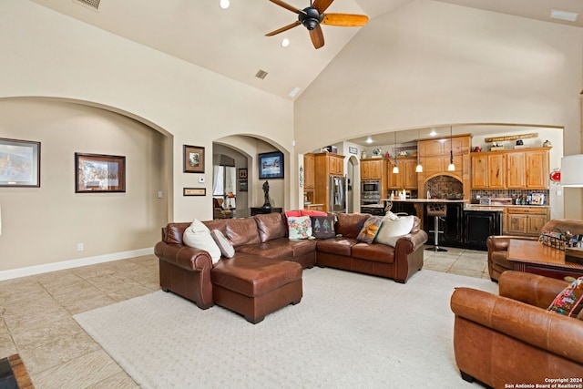 living room featuring light tile patterned floors, high vaulted ceiling, and ceiling fan