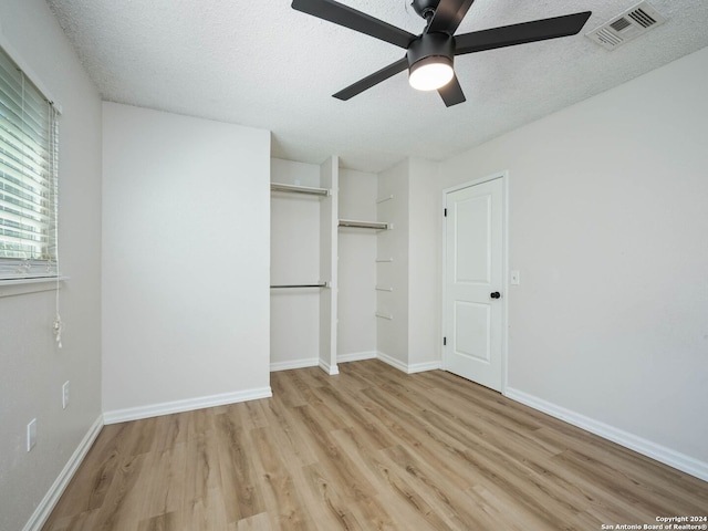 unfurnished bedroom with a closet, ceiling fan, a textured ceiling, and light hardwood / wood-style flooring