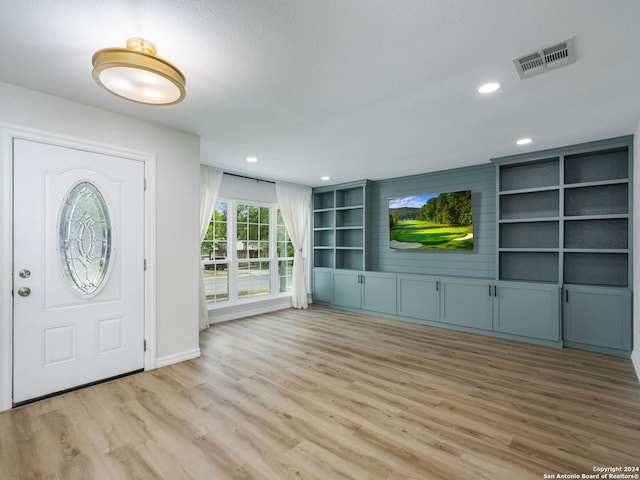 foyer with light hardwood / wood-style floors and a textured ceiling