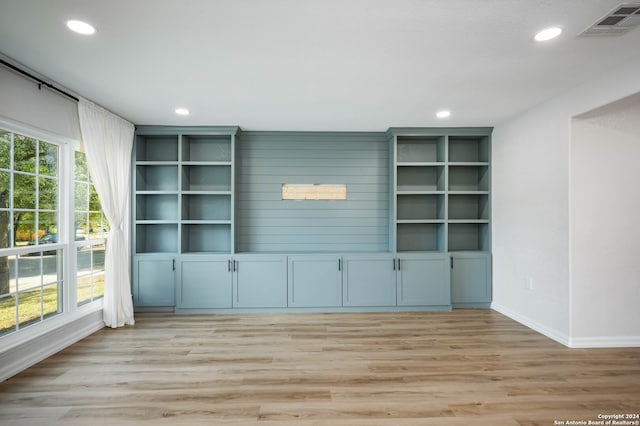 unfurnished living room featuring a wealth of natural light and light hardwood / wood-style floors