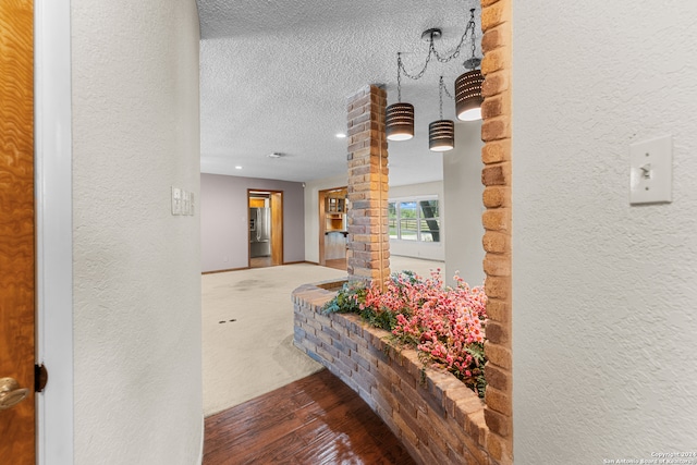 interior space with a textured ceiling and hardwood / wood-style floors