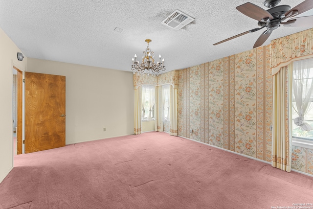 empty room featuring ceiling fan with notable chandelier, a textured ceiling, and carpet floors